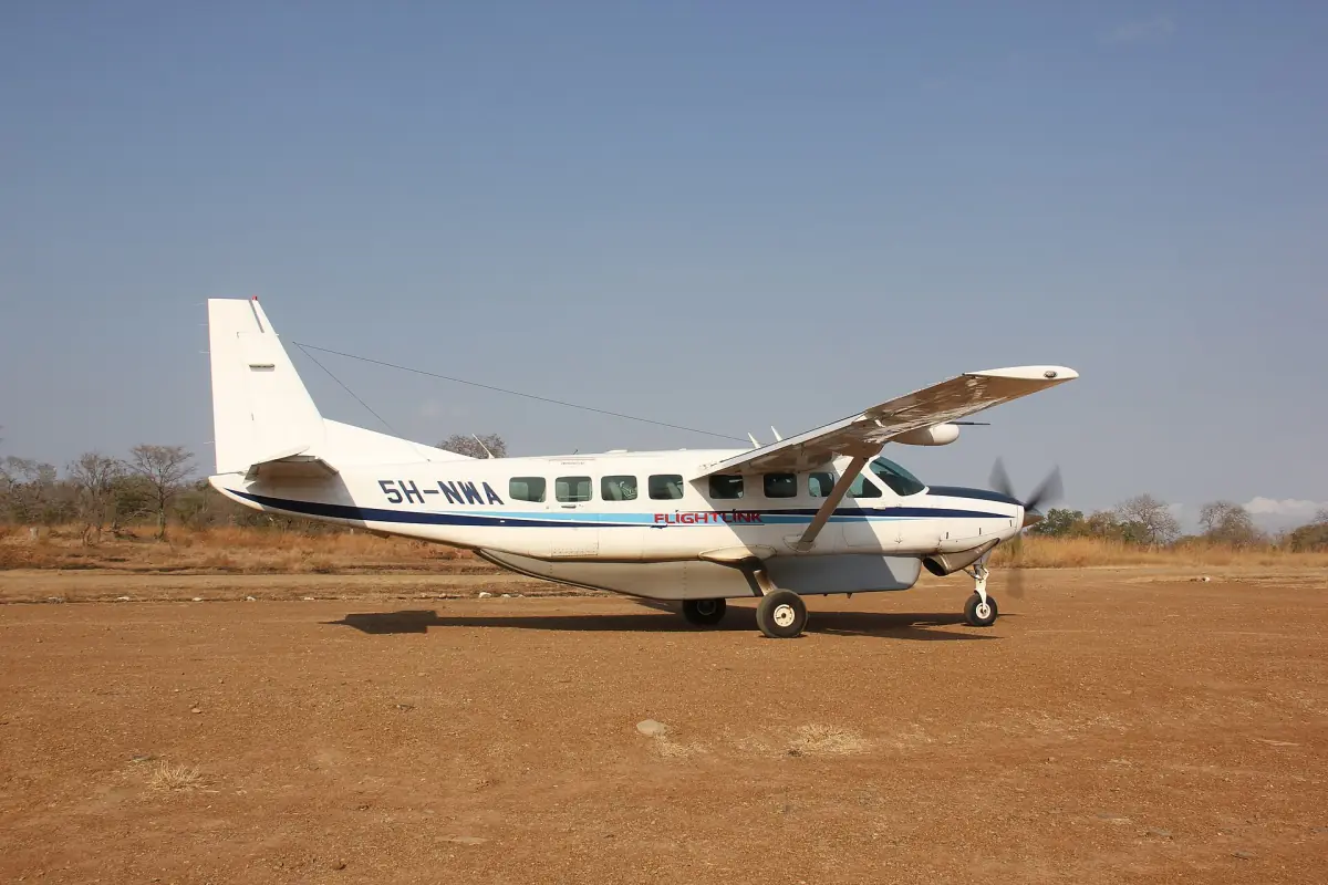 Light aircraft parked on a red dirt bush airstrip