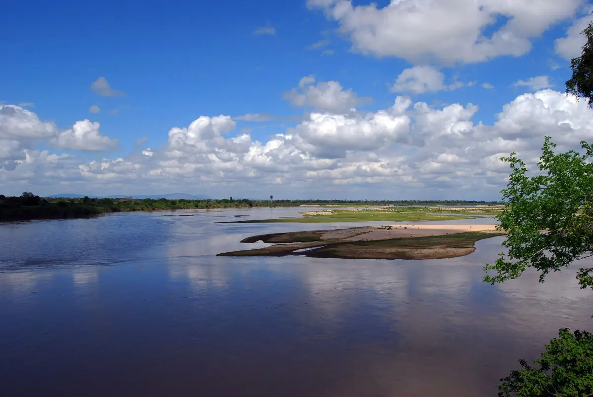 Brede Rufiji-rivier met zandbanken onder een blauwe lucht met wolken